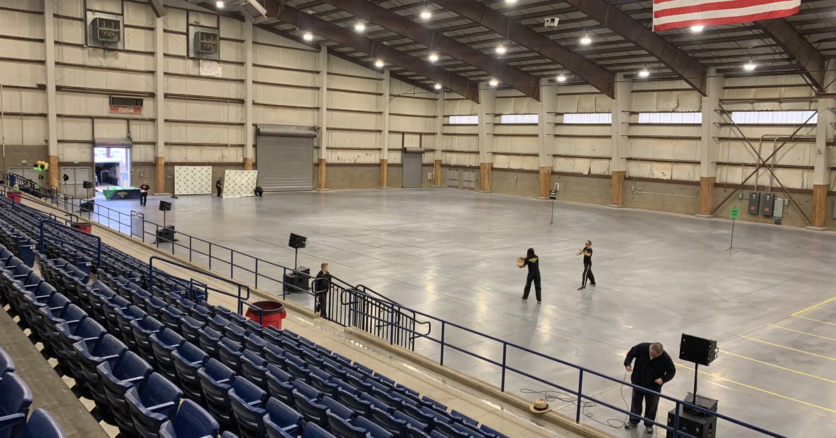 An arena floor and grandstand before doors, SwissMixx speakers on stands at the edge of the floor