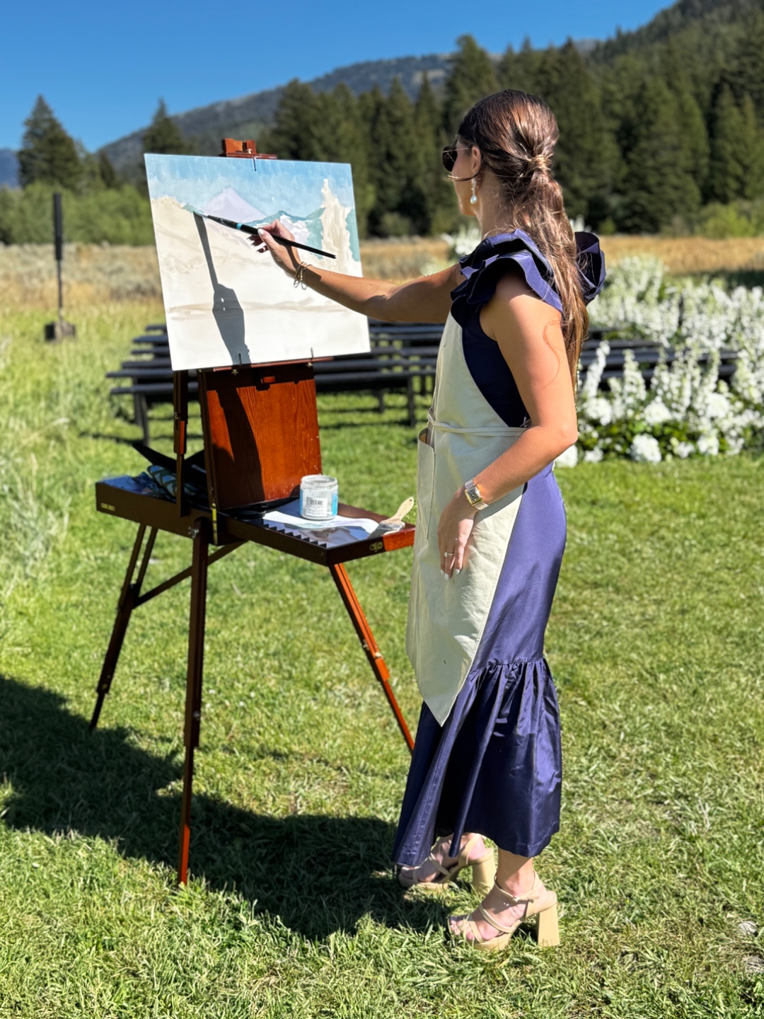 Live wedding painter creating mountain landscape artwork during ceremony at Teton Valley estate