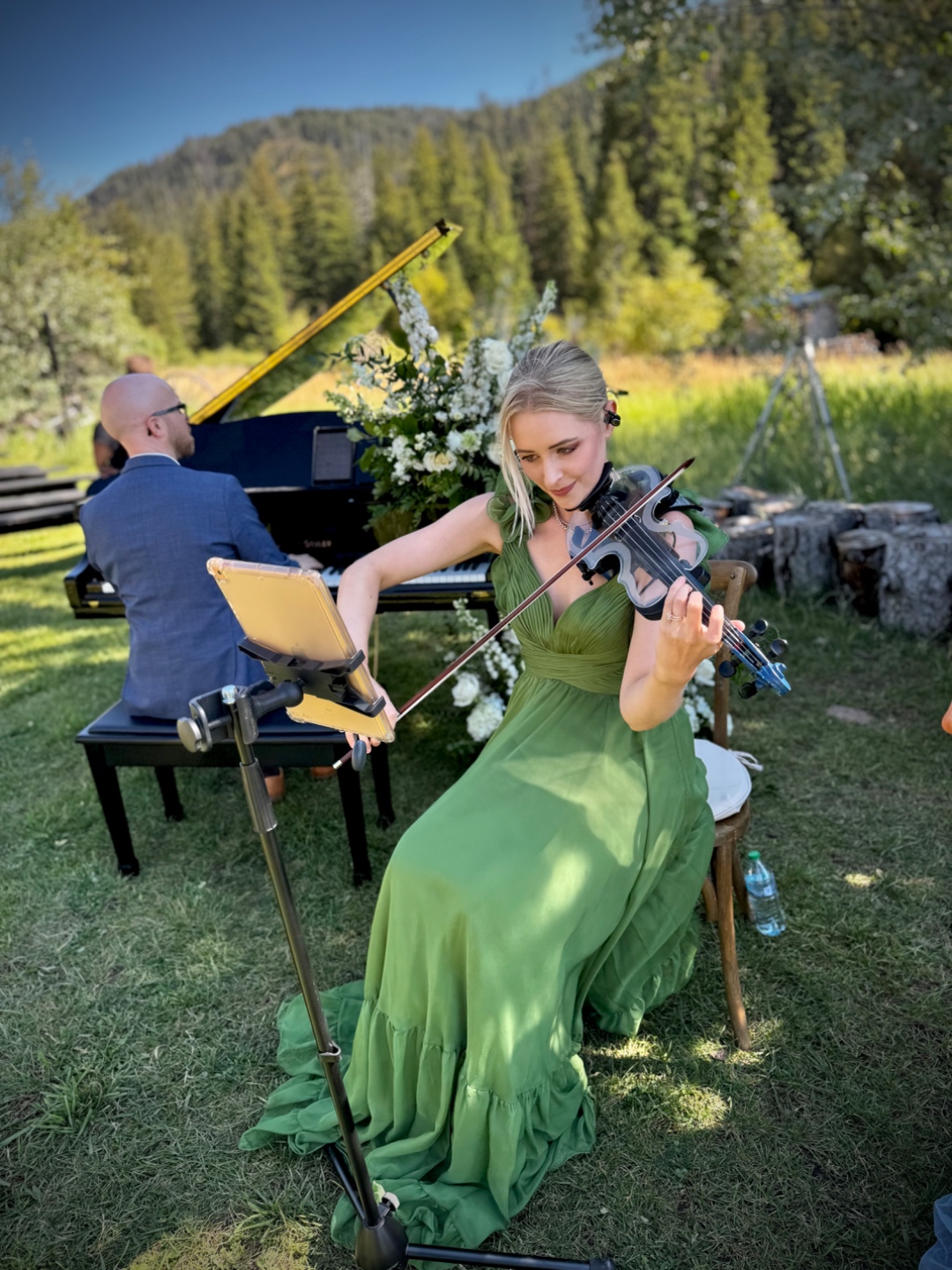 Violinist performing at outdoor mountain wedding ceremony, Teton peaks in background