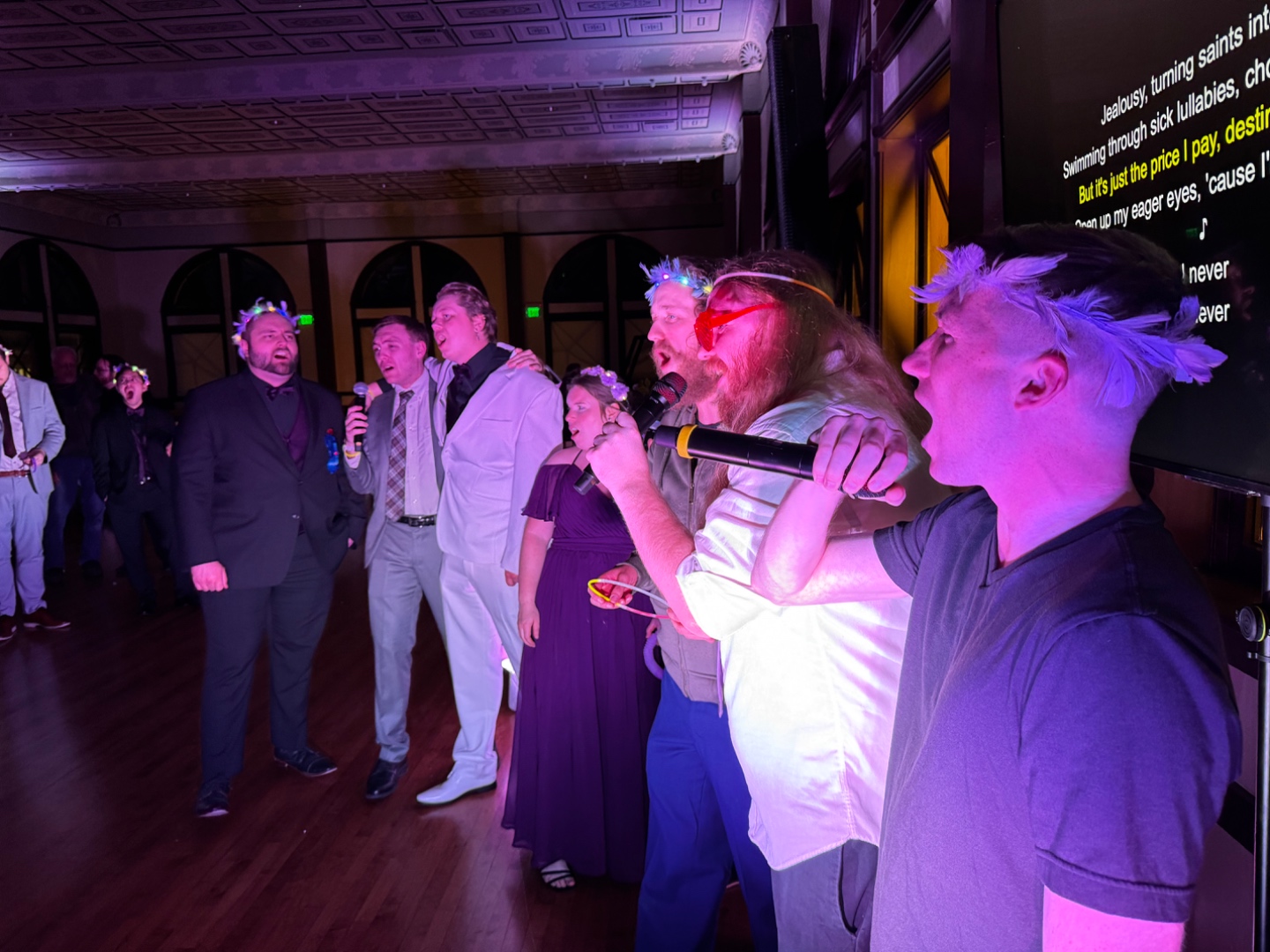 Guests singing karaoke in a ballroom with lyrics displayed on screen, SwissMixx Audio karaoke DJ service