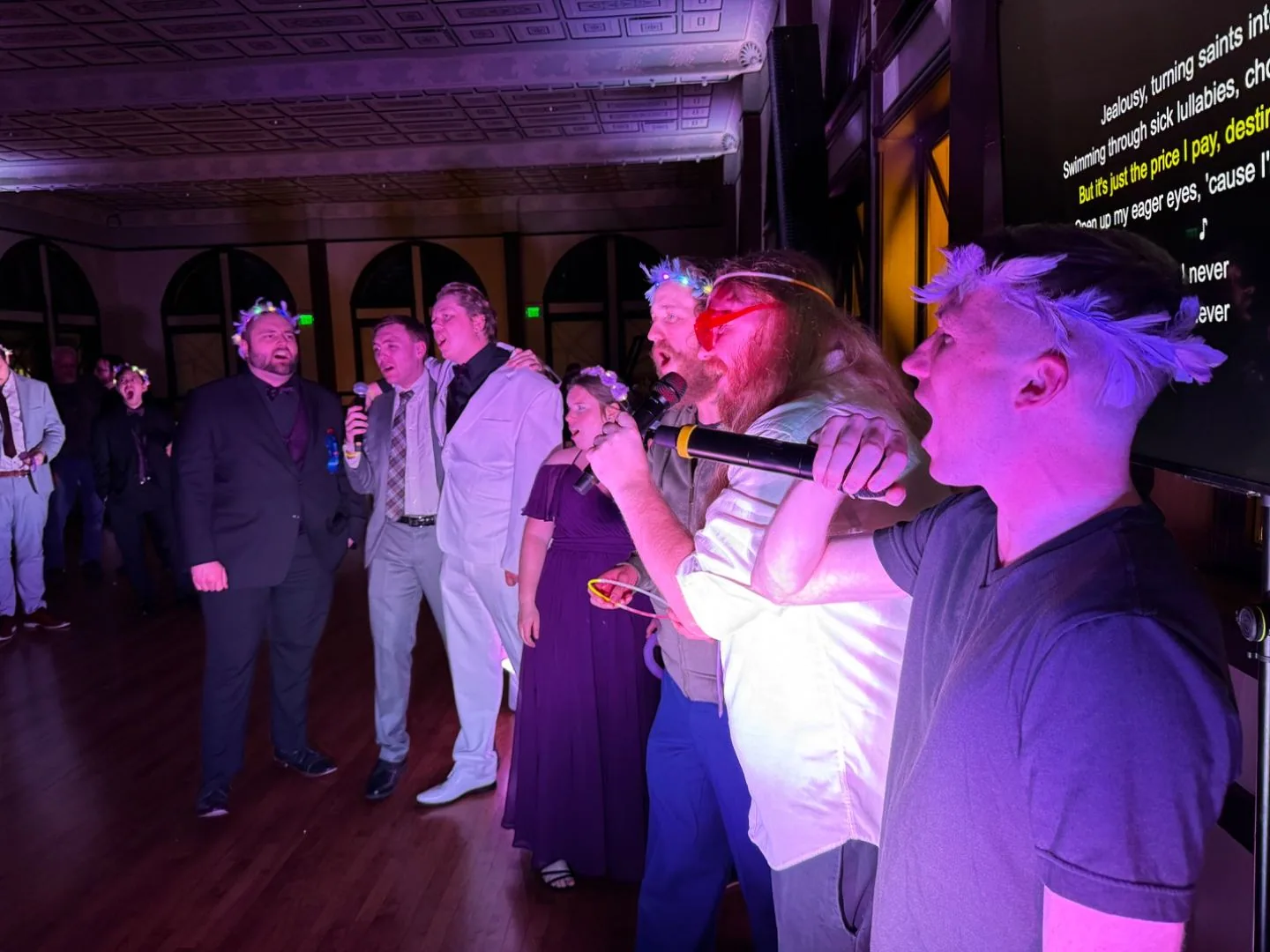 Guests singing karaoke in a ballroom with lyrics displayed on screen, SwissMixx Audio karaoke DJ service