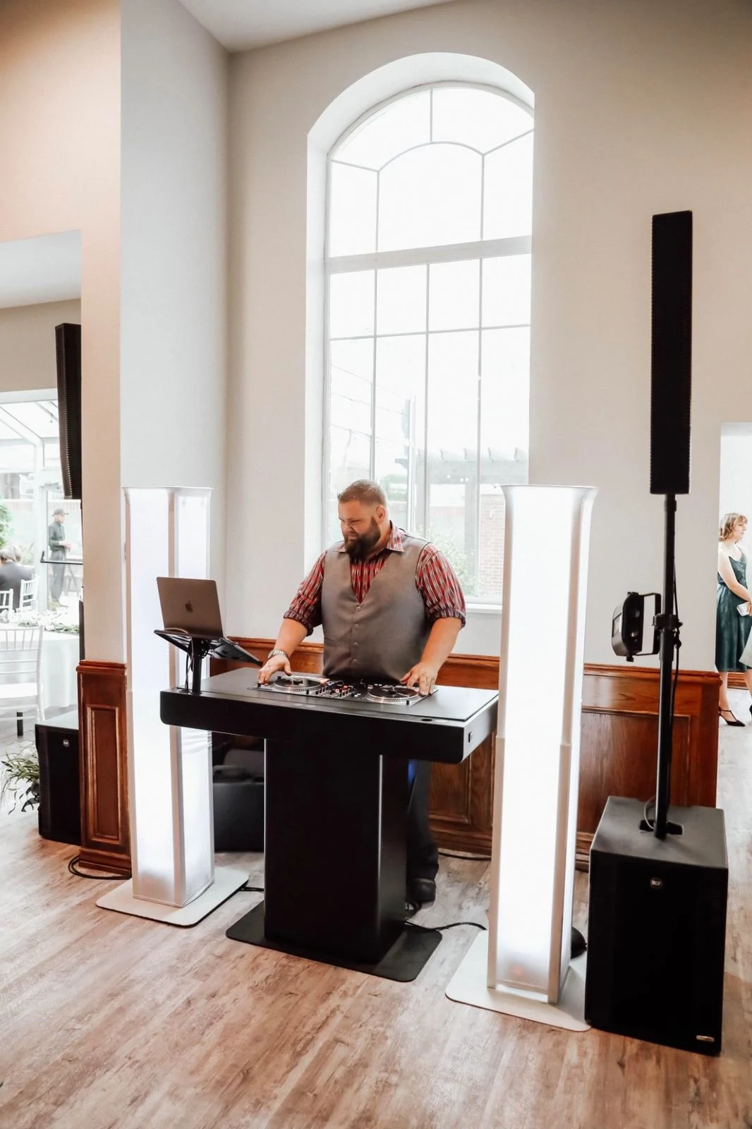 Mark Christiansen of SwissMixx Audio at his DJ booth inside an elegant white wedding venue