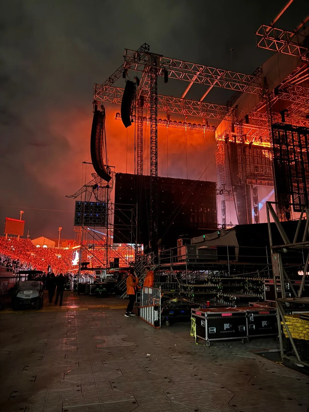 Side-stage view of the Post Malone concert at Rice-Eccles Stadium with line arrays, massive LED wall, smoke, and a sold-out crowd in orange and red light
