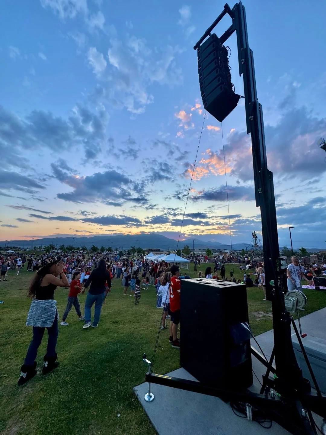 RCF HDL26 line array system deployed on 20ft Tower Lift K-50 at outdoor event in Treasure Valley Idaho by SwissMixx Audio with large crowd at sunset