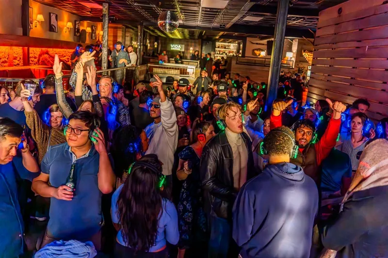 Silent disco crowd wearing glowing LED headphones at a packed SwissMixx Audio event