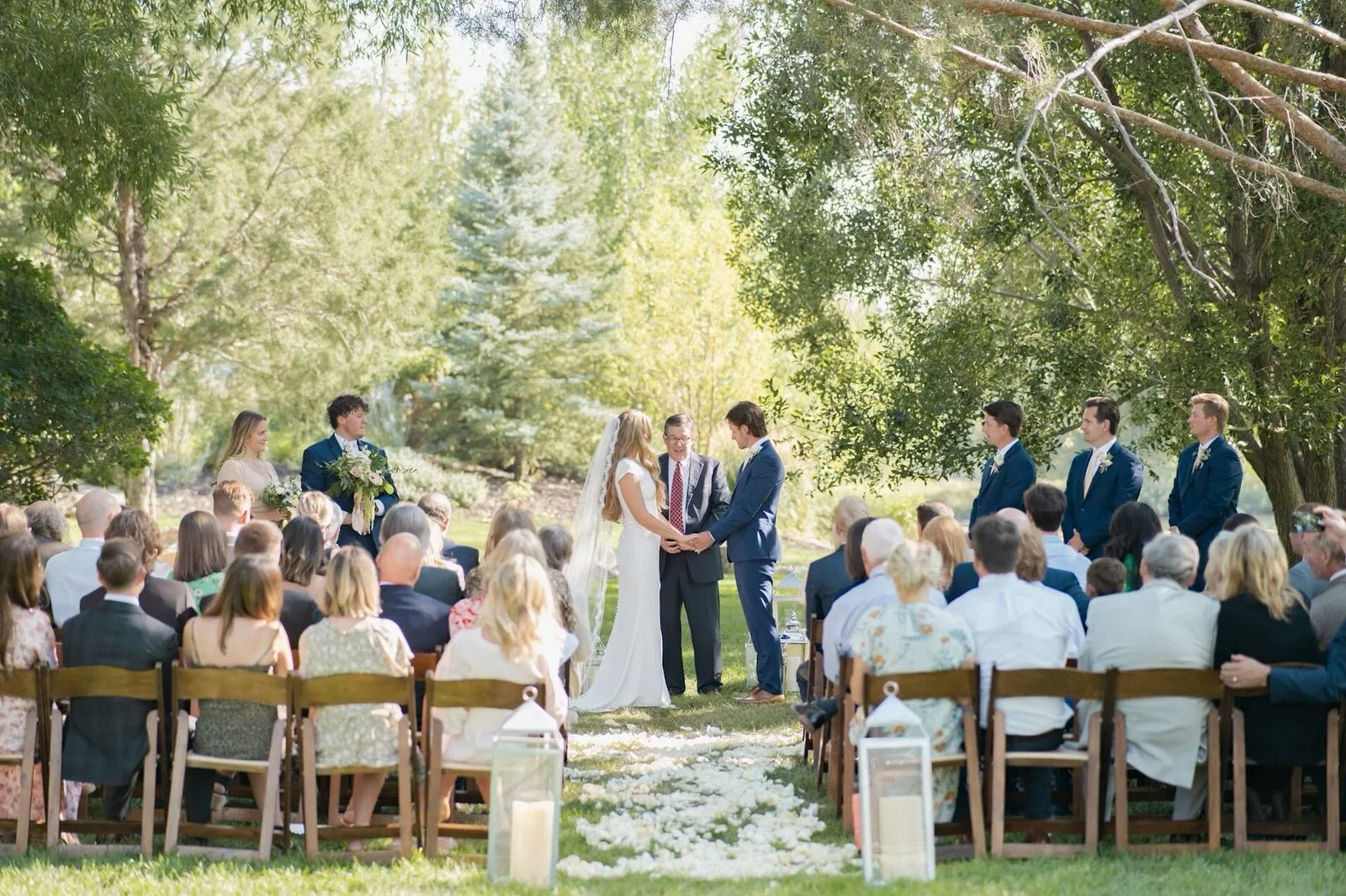 Guests seated at an outdoor Idaho wedding ceremony among tall trees