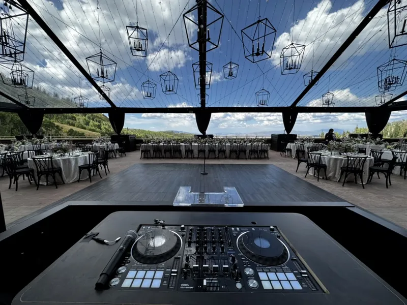 DJ decks overlooking an open air wedding venue with hanging lanterns and mountain views near Mountain Home Idaho, SwissMixx Audio